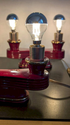 Paire de lampes Art Déco céramique bordeaux et or allumées