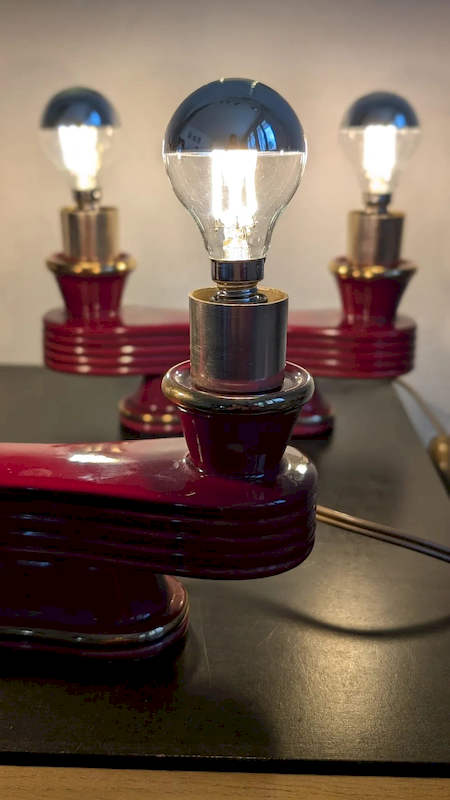 Paire de lampes Art Déco céramique bordeaux et or allumées