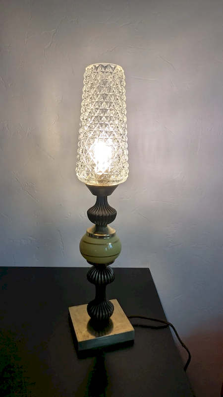 Lampe Hollywood Regency allumée avec reflets lumineux sur les murs