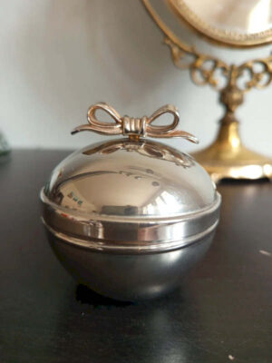 Boîte à bijoux vintage argentée sphérique avec nœud doré sur couvercle