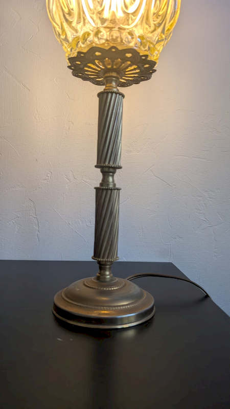 Détail du pied sculptural en métal doré de la lampe bougeoir vintage