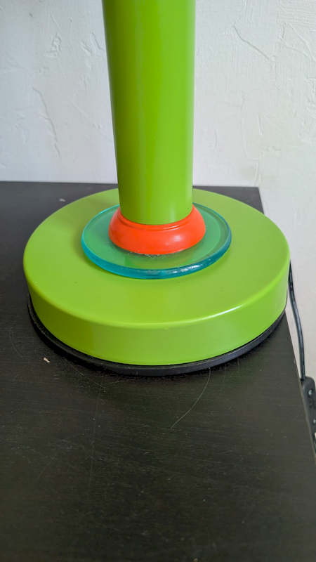Détail du socle rond vert avec sa collerette transparente et son câble noir neuf