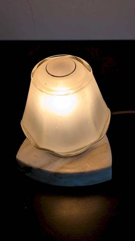 Détail des reliefs sculptés sur le globe en verre ambré de la lampe veilleuse