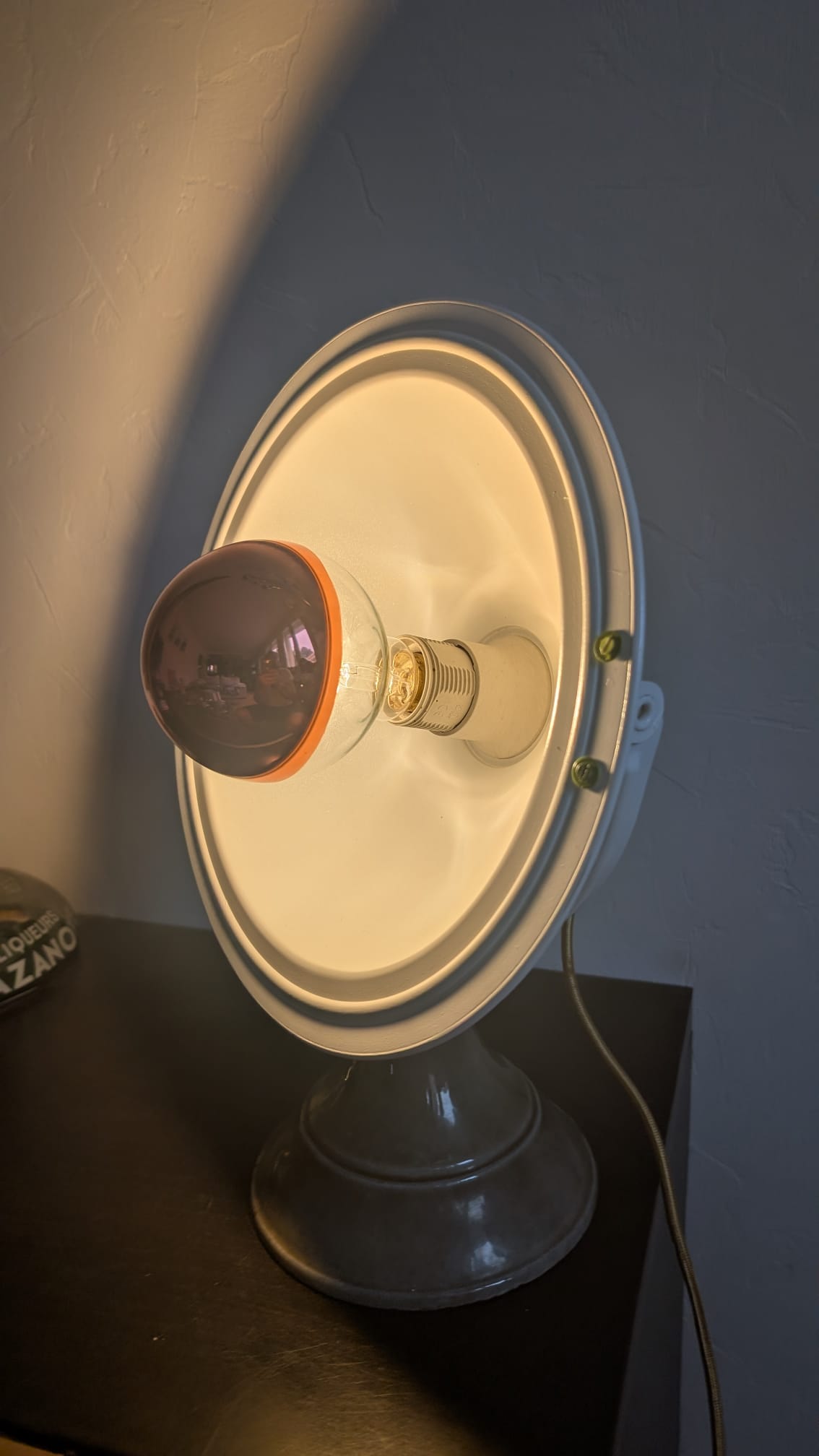 Lampe d'atelier restaurée allumée vue de trois-quarts