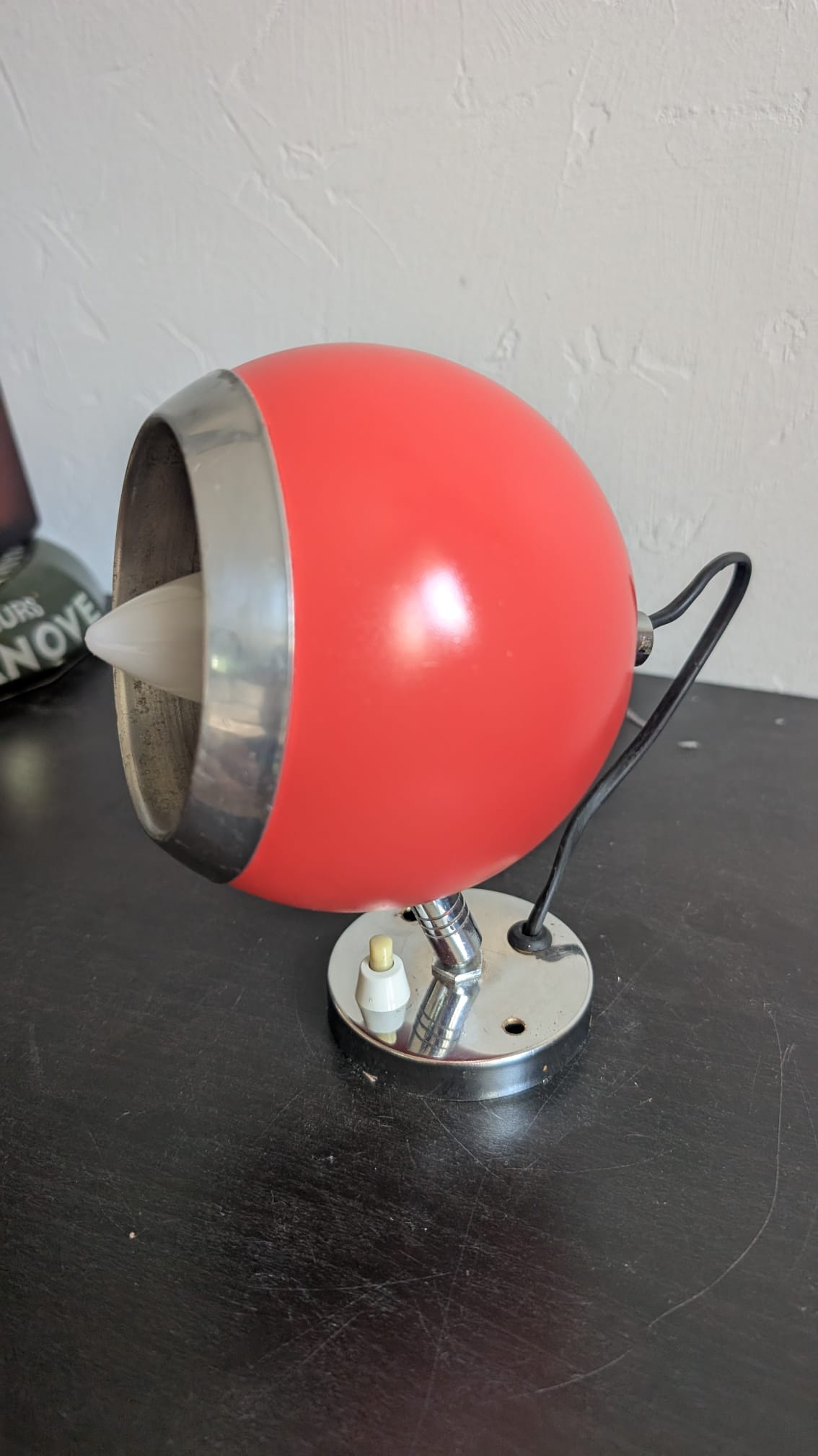 Silhouette de profil d'une applique eyeball vintage rouge corail avec ampoule E14 installée