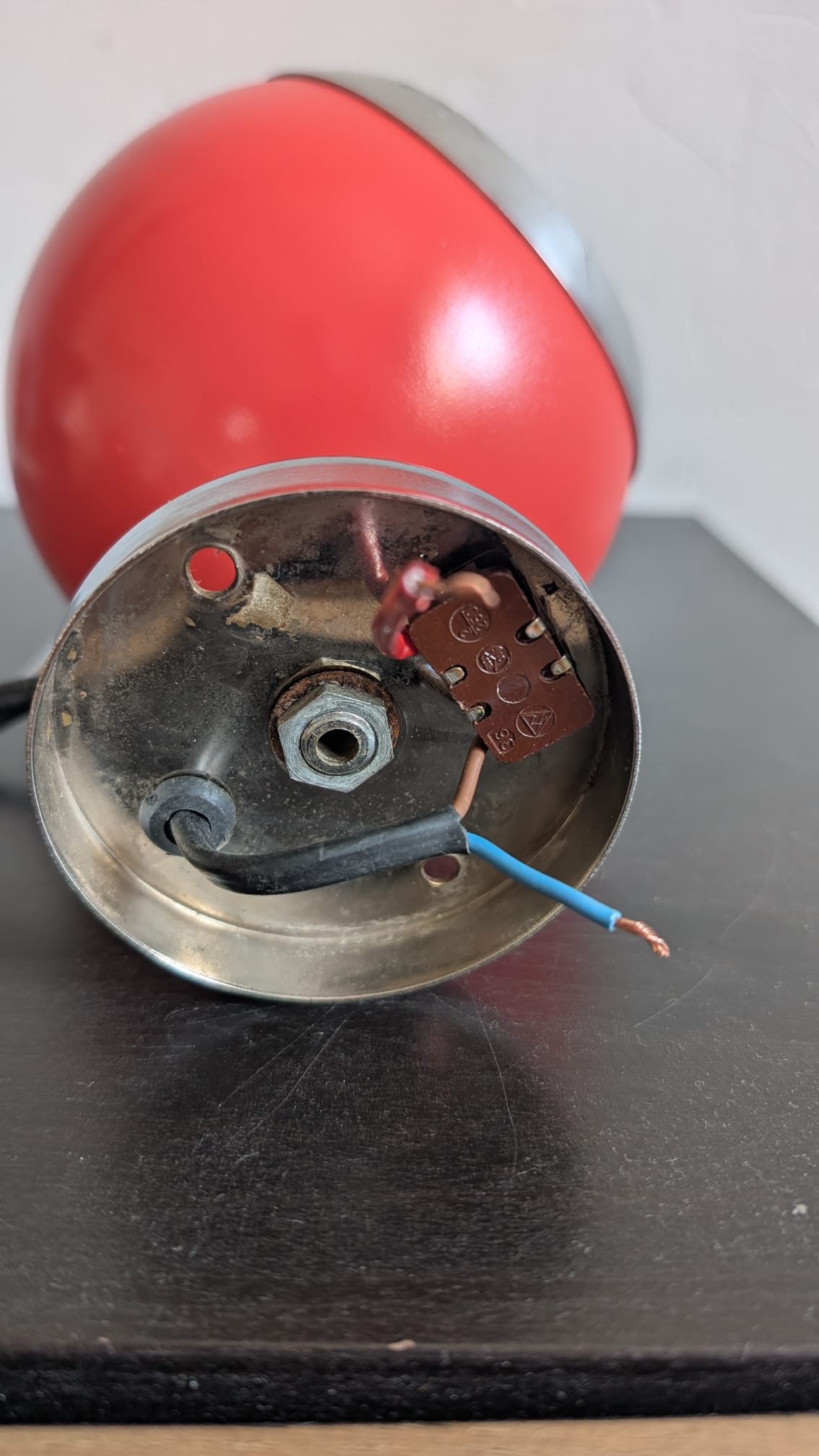 Dessous du socle en métal de l'applique eyeball vintage montrant l'interrupteur et le câblage interne
