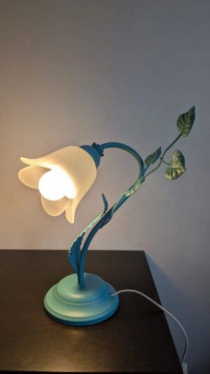 Éclairage d'ambiance chaleureux d'une lampe fleur vintage sur meuble noir