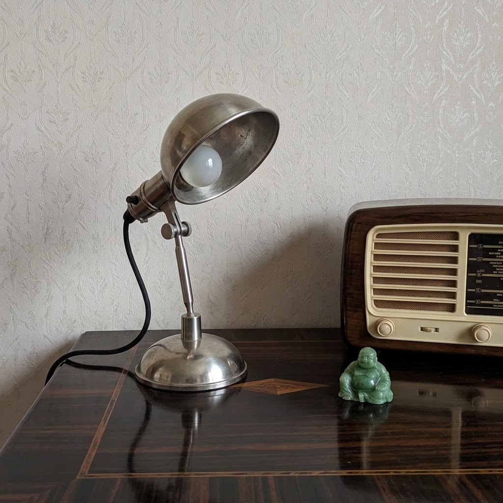 Lampe industrielle en acier brossé des années 1930 posée à côté d'une radio vintage