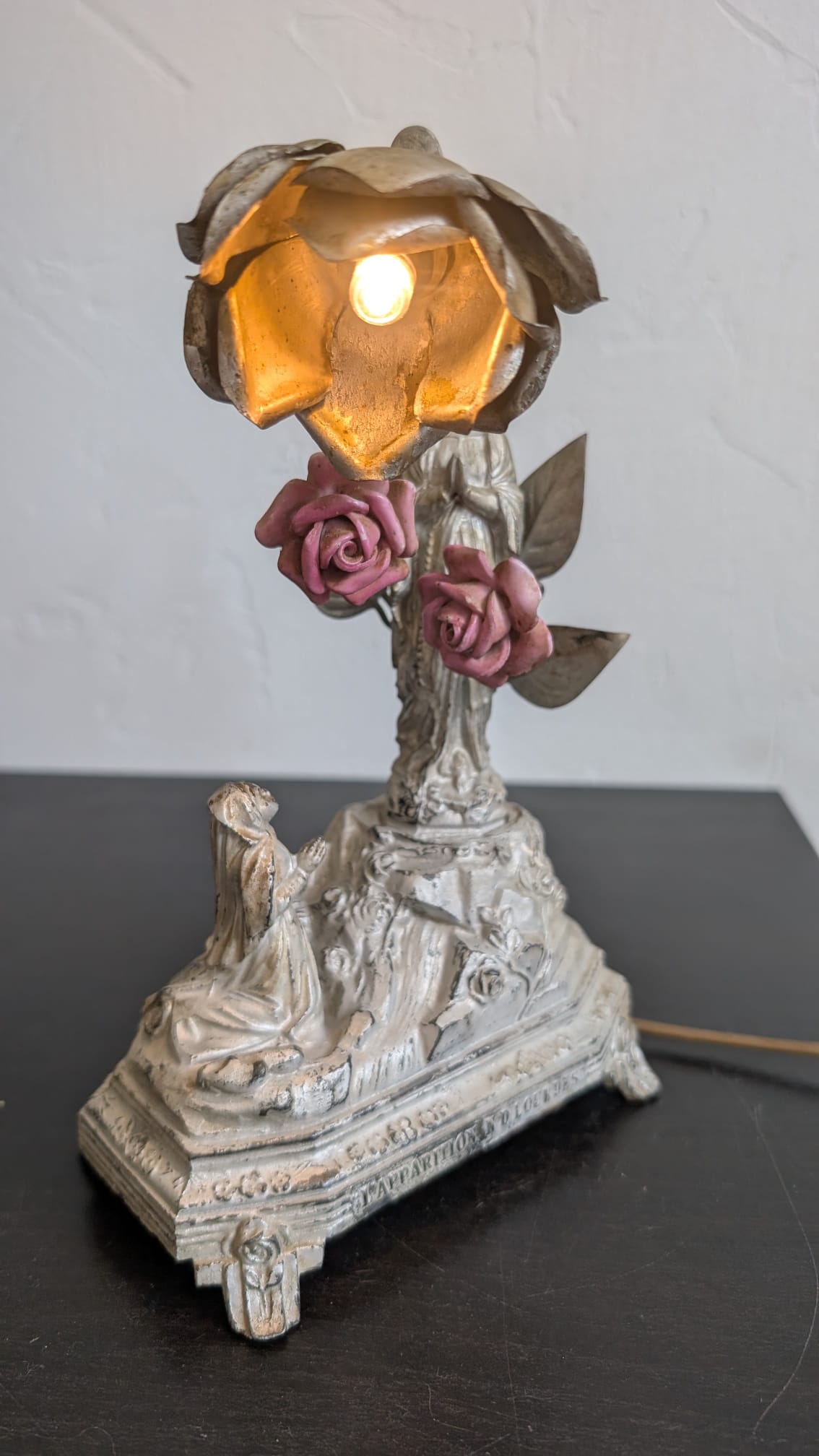 Gros plan sur l'abat-jour floral allumé d'une lampe musicale Notre-Dame de Lourdes