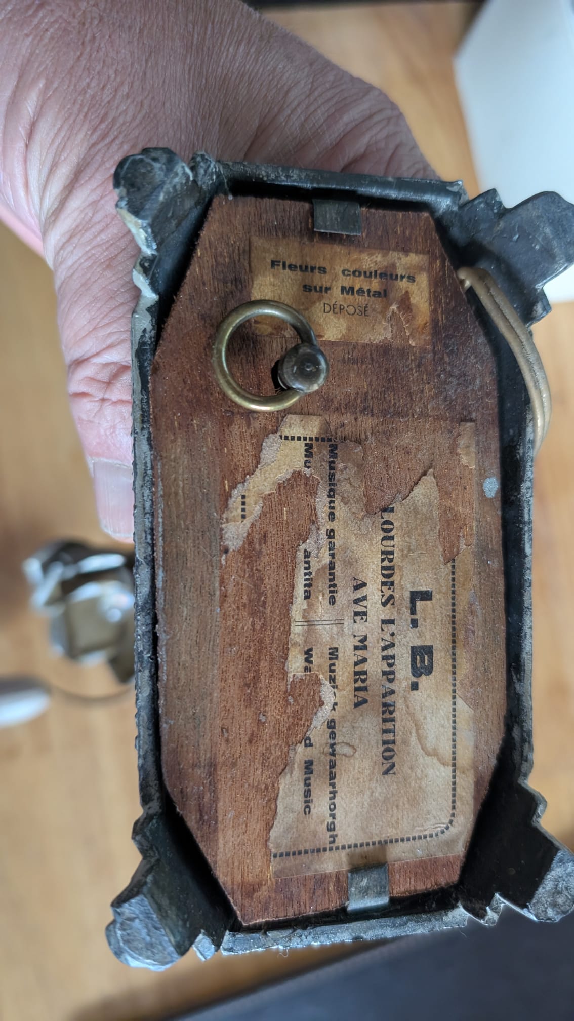 Dessous du socle en bois d'une lampe musicale Notre-Dame de Lourdes avec clé et étiquette Ave Maria