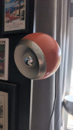 Spot à pince Eyeball orange fixé sur une étagère en situation
